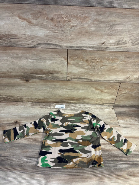 Front flat lay of toddler waffle-knit camo long-sleeve shirt showing ribbed texture and tan-green pattern on wood background