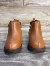 Brown toddler ankle boots with side zippers on wood background