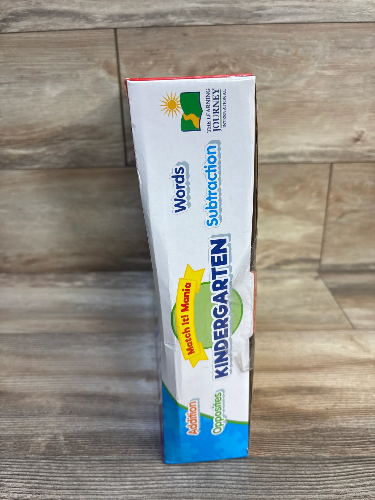 Kindergarten educational game box with words, subtraction, addition, and opposites on wood floor