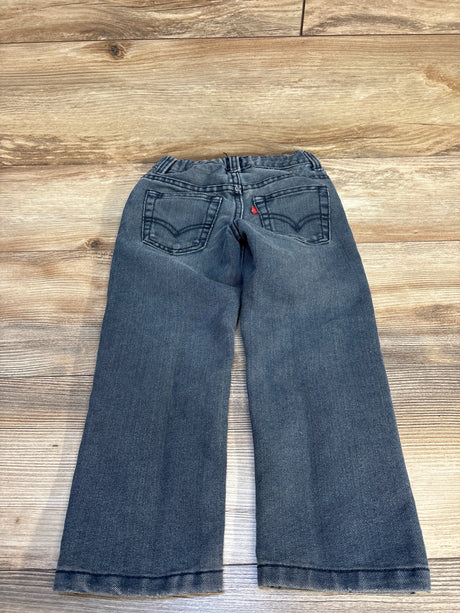Kids' dark wash denim jeans with back pockets on wooden floor