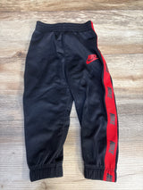Black Nike kids track pants with red side stripes and logo, elastic waist and cuffs