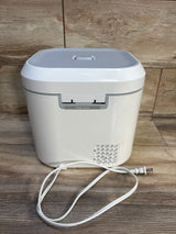White electric diaper wipe warmer with power cord on wooden floor background
