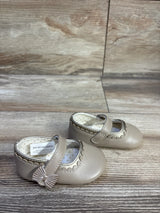 Front three-quarter view of Mayoral toddler Mary Jane shoes in tan showcasing scalloped trim, bow detail and polka dot lining on wood grain background