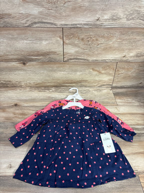 Front view of girls 2pc dress set with navy polka dot dress over pink floral dress on hangers on wood floor