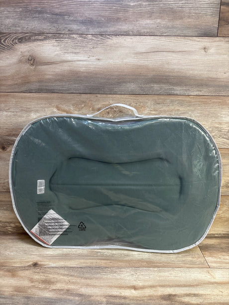Top-down view of Snuggle Me Curve Lite baby lounger with moss cover in clear bag showing handle and contoured interior