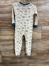 Back view of Wonderluxe Dinosaur blanket sleeper showcasing blue dinosaur print, teal cuffs and dotted non-slip feet on wood plank background