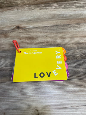 Yellow baby play guide card titled The Charmer for 3-4 months from Lovevery on wooden surface
