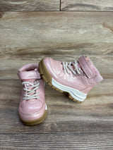 Pair of pink toddler boots with white laces and brown soles on wooden floor