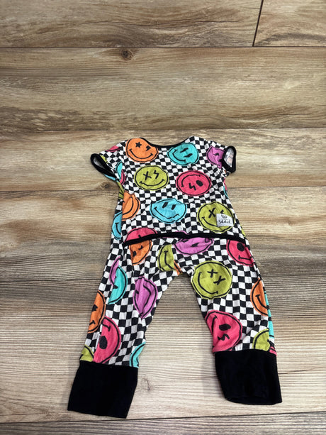 Flat lay of The Simple Seed bamboo day to night romper with colorful smiley faces, checkerboard pattern, and black cuffs