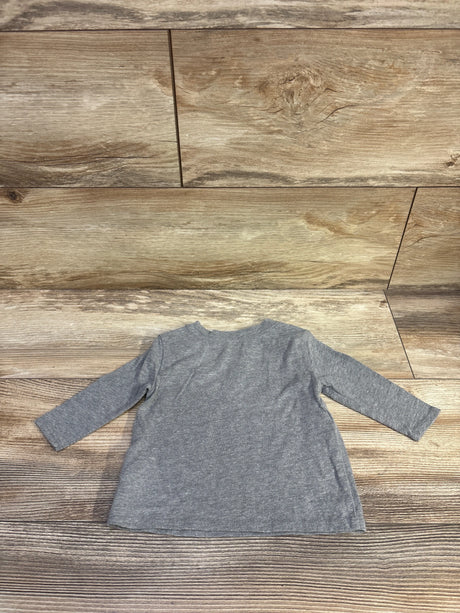 Back view of grey Old Navy long-sleeve baby shirt (3–6M) showing A-line hem on wood floor background