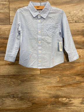 Light blue long-sleeve button-up toddler shirt with pocket and Old Navy tag on wooden floor