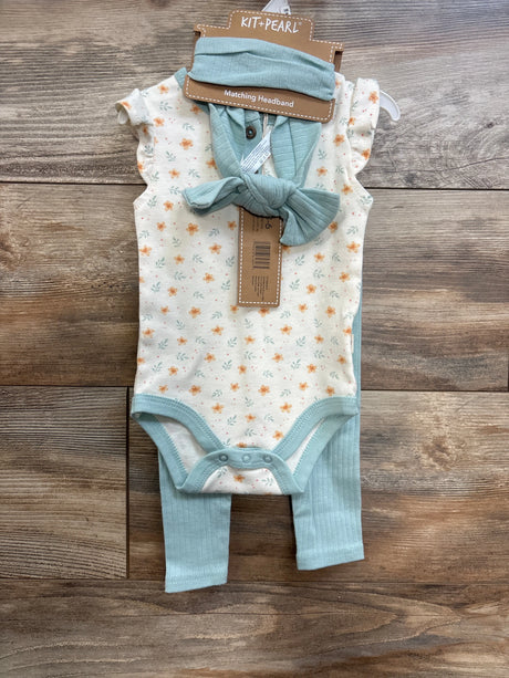 Front flat lay of ivory floral short-sleeve bodysuit with ribbed mint pants and matching mint headband on wood background