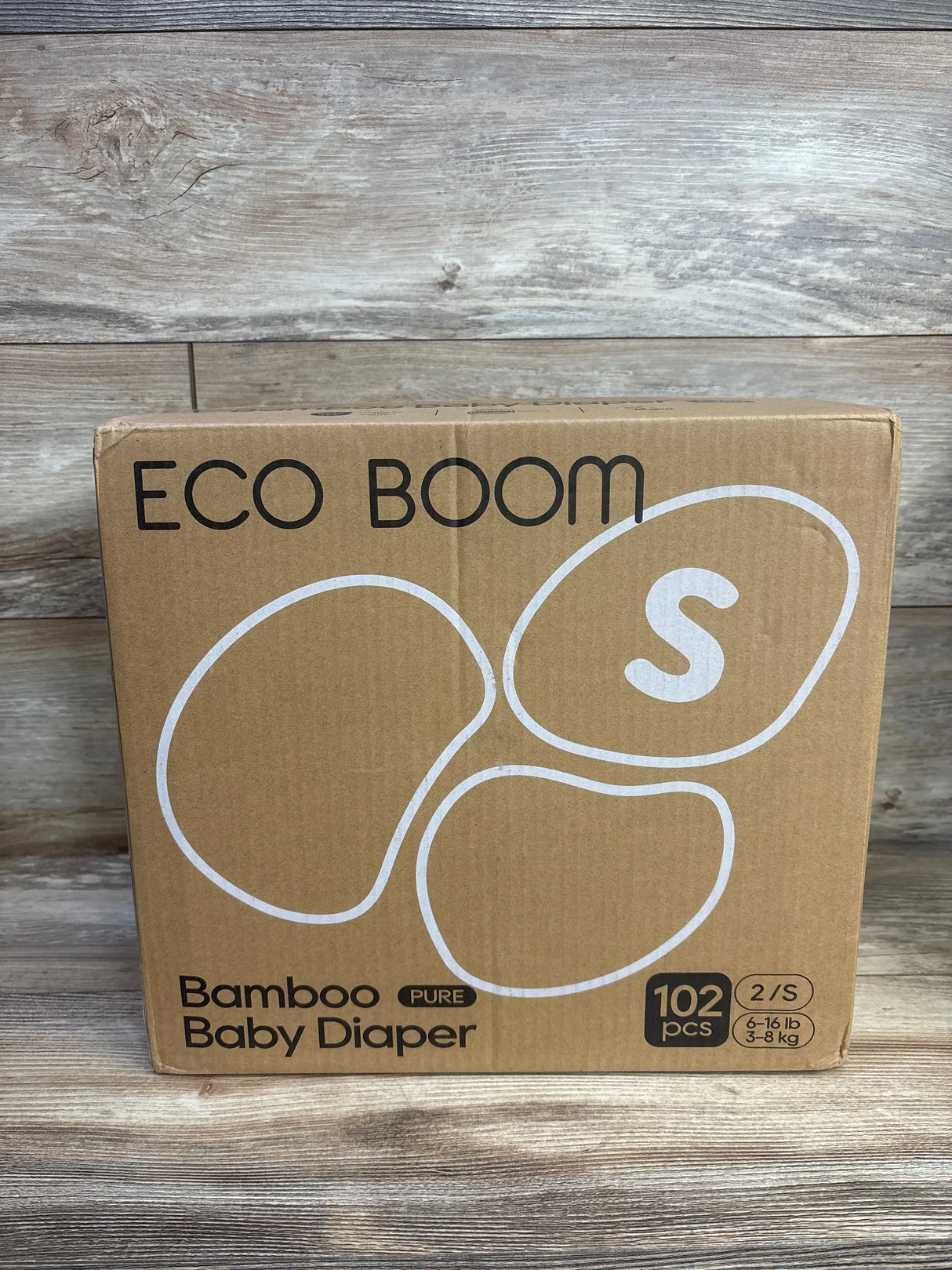 Front view of Eco Boom bamboo baby diaper box showing size S badge, 102-count label and bamboo branding on a wooden surface