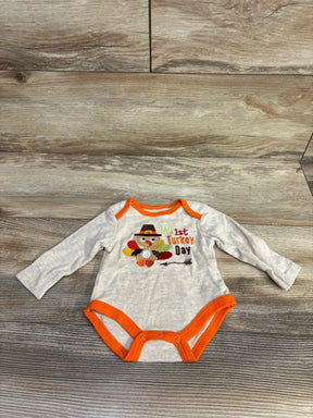 Baby bodysuit with My 1st Turkey Day and turkey graphic on wood floor