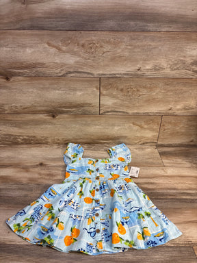 Blue baby dress with orange & palm tree print, button front, laid on wood floor
