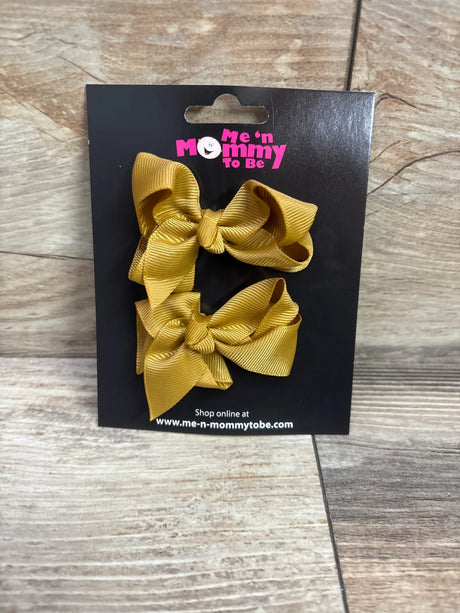 Two caramel-colored grosgrain hair bows on a black Me n Mommy To Be packaging card.