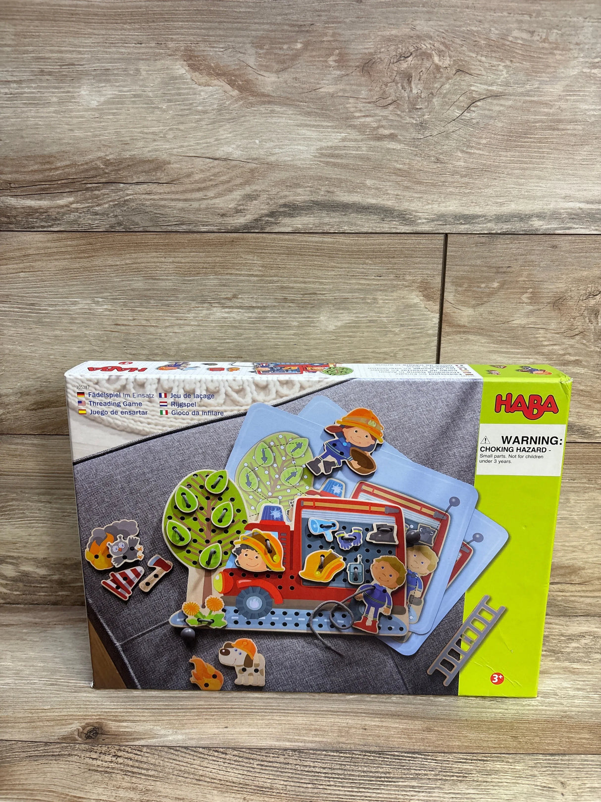 HABA threading game for kids with firefighter theme, box on wooden background