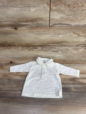 White long sleeve baby shirt with buttons and collar on wooden background