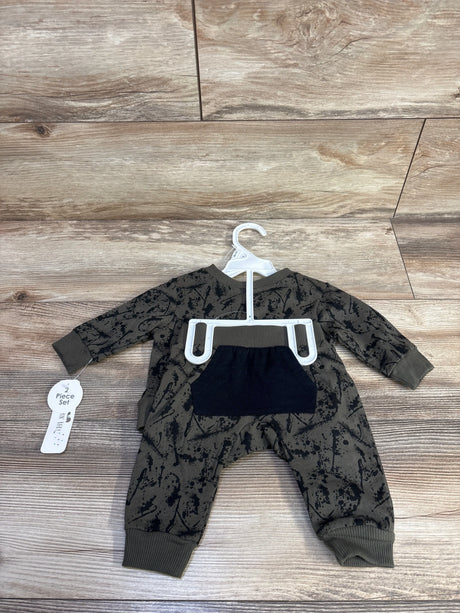 Flat lay of olive green Bloomin Baby 2-piece sweatshirt and joggers with black splatter print and front pocket on wood floor