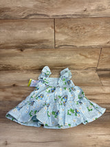 Top down view of light blue Bluey floral baby dress size 12 months showcasing Swiss dot texture, ruffled skirt on wood floor background