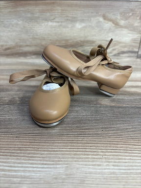 Tan kids’ tap dance shoes with ribbons and metal taps on wooden floor
