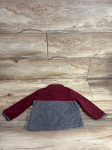 Kids fleece jacket with maroon sleeves and gray body laid flat on wooden surface