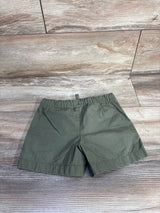 Flat-lay of Carter's green toddler drawstring shorts showing elastic waistband and straight hem on light wood background