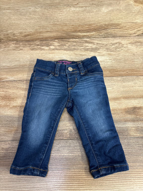 Toddler dark blue denim jeans with front pockets and button closure on wooden background
