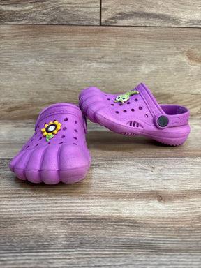 Purple kids toe shoes with flower and caterpillar charms on wood background