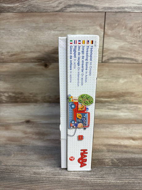 HABA thread game toy box for ages 3 and up on wood background