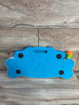 Bottom of Rolo's Keyboard toy showing blue textured base with battery door, black feet, and orange microphone on wood