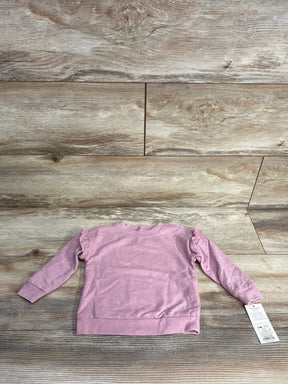 Light pink long sleeve toddler sweatshirt with ruffle details on wooden background