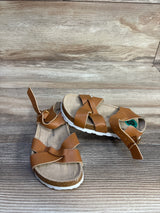 Three quarter view of Lucky Brand Kiara sandals, brown criss cross straps, ankle buckle, cork footbed on wood, size 8C