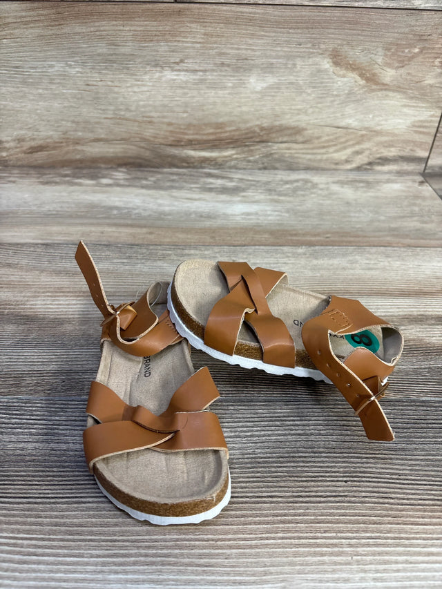 Three quarter view of Lucky Brand Kiara sandals, brown criss cross straps, ankle buckle, cork footbed on wood, size 8C