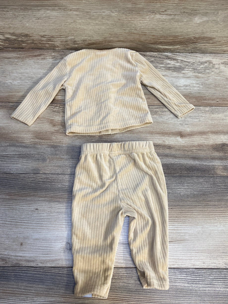 Beige ribbed toddler outfit with long sleeve top and matching pants on wood background