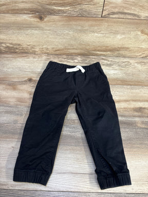 Flat lay of Cat & Jack toddler black drawstring joggers showing white drawstring, elastic waistband and cuffs on light wood background