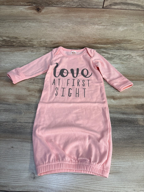 Pink baby gown with 'love at first sight' text, long sleeves, laid flat on wood floor
