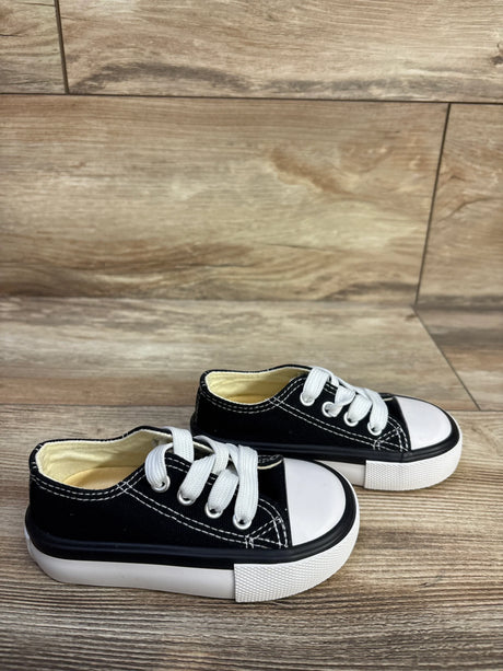 Angled side view of toddler OPOEE black low-top sneakers with white toe caps and thick white platform soles, size 5C on wood
