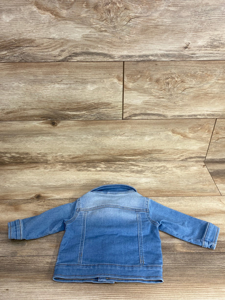 Back view of a blue denim jacket for kids laid flat on wood floor background, children's resale clothing