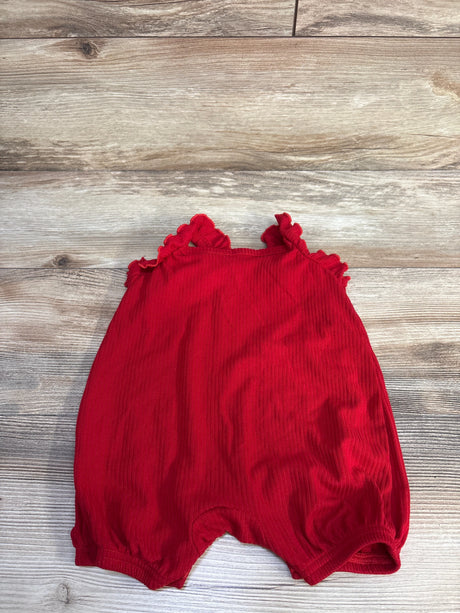 Flat lay of red Disney Baby Minnie Mouse shortie romper (6-9m) showing ruffled shoulder straps and gathered elastic leg openings on light wood background