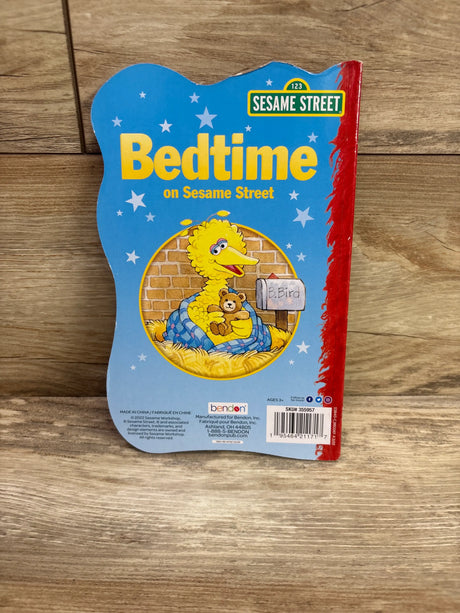 Front cover of Bedtime on Sesame Street hardcover book showing Big Bird with a teddy bear under a blanket against blue stars