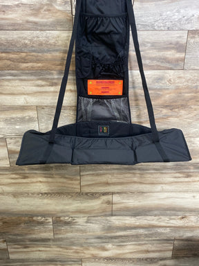 Front view of black Baby Change-N-Go hanging changing station with padded pad, straps, mesh pocket, and orange warning label