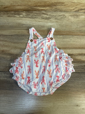 Baby romper with red lobster print and ruffled sides on wood background