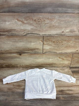 White long sleeve toddler sweatshirt displayed flat on wood background