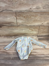 Top down of green Winnie the Pooh baby rashguard size 9M showing back zipper and all over print on wood background