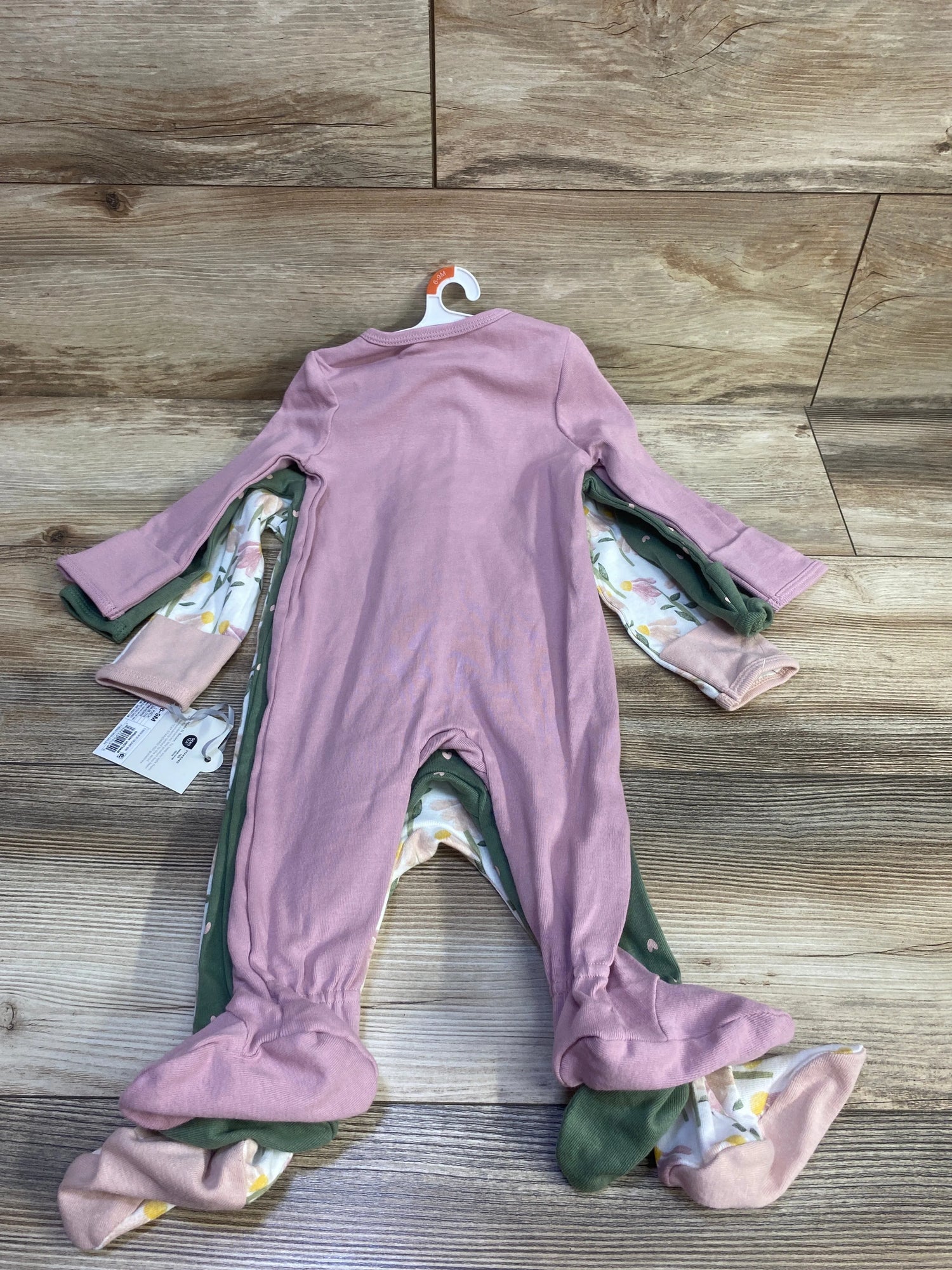 Front view of three Cloud Island sleepers in pink, green, and printed patterns with long sleeves and attached feet