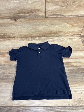 Navy blue short-sleeve polo shirt with collar and buttons on wooden floor