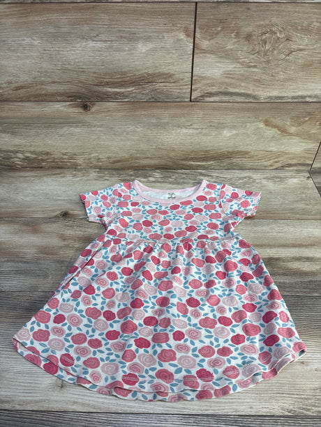 Flat lay of toddler floral dress by Touched By Nature showing pink rose print and gathered waist on wood plank background