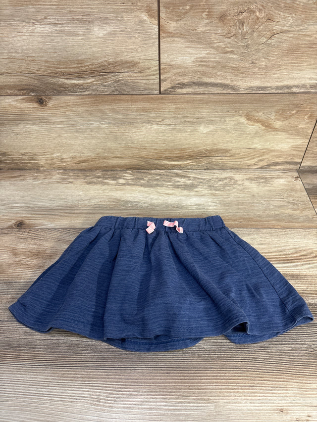 Front view of Cat & Jack navy blue toddler drawstring skort showing elastic waistband with two pink bows on wood background