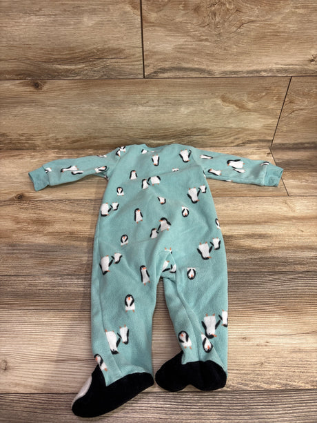 Front view of Carters blue blanket sleeper in size 9 months with penguin print and black footies on a wood floor